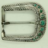 A South American white metal belt buckle, decorated in relief and set with nine graduating