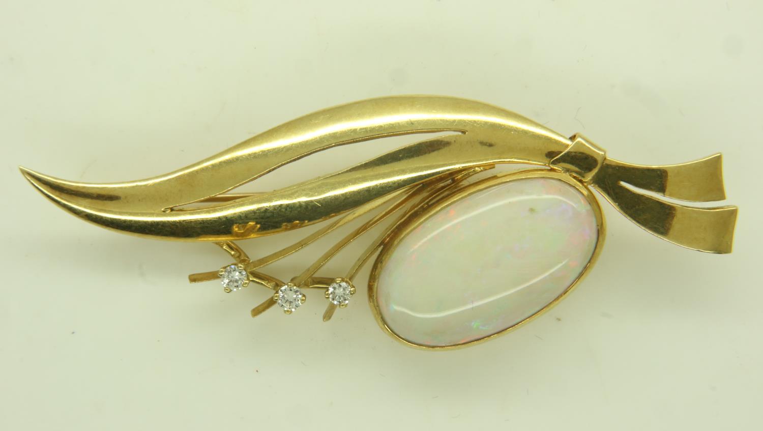 Continental gold brooch (unmarked), set with a large oval cabochon opal and three diamonds, L: 65