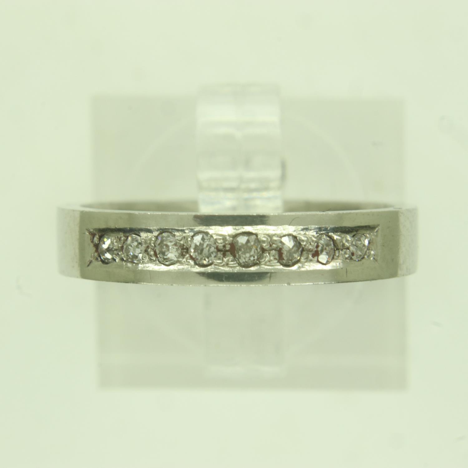 Contemporary platinum band ring, channel-set with eight diamonds, size M/N, 5.4g. UK P&P Group 0 (£