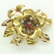A continental 18ct gold brooch, of floral design with raised old-cut diamonds and central ruby,