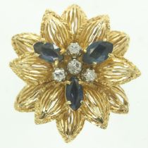 A continental 18ct gold ring, raised floral design set with sapphires and diamonds, comfort shank,