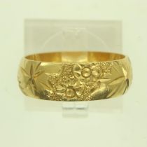 An 18ct gold wide profile decorated band ring, size N/O, 5.4g. UK P&P Group 0 (£6+VAT for the