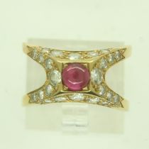 A continental 18ct gold ring, pyramidal setting with a cabochon ruby and diamond-set shoulders,