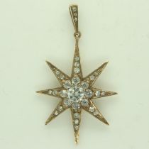 An Edwardian 9ct gold star-form pendant, set with graduating white sapphires, drop L: 48 mm, 5.8g.