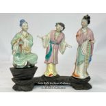 a group of three Japanese famille rose porcelain figures on a carved wooden base, 16cm high / AN9