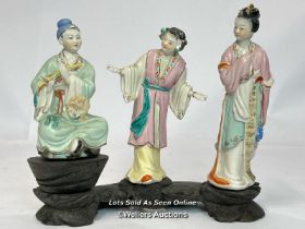 a group of three Japanese famille rose porcelain figures on a carved wooden base, 16cm high / AN9