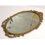 A small oval wall mirror with decorative metal frame, 48cm high