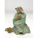 *Porcelain glazed figure of an old chinese man drinking tea, 9cm high (Lot subject to VAT) / AN3