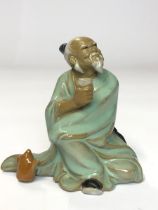 *Porcelain glazed figure of an old chinese man drinking tea, 9cm high (Lot subject to VAT) / AN3