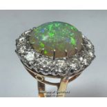 Opal and diamond cluster ring with an oval opal measuring 14.6mm x 12.2mm surrounded by 14 round