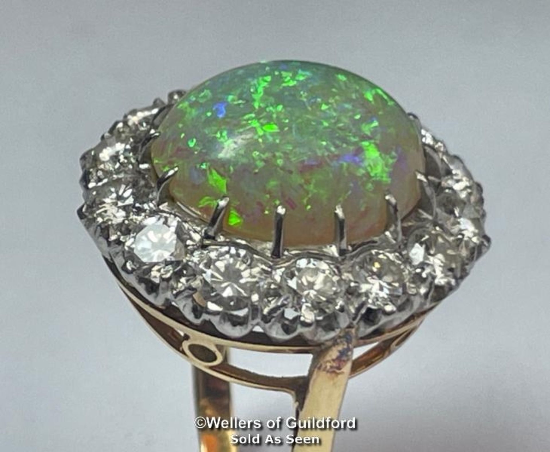 Opal and diamond cluster ring with an oval opal measuring 14.6mm x 12.2mm surrounded by 14 round