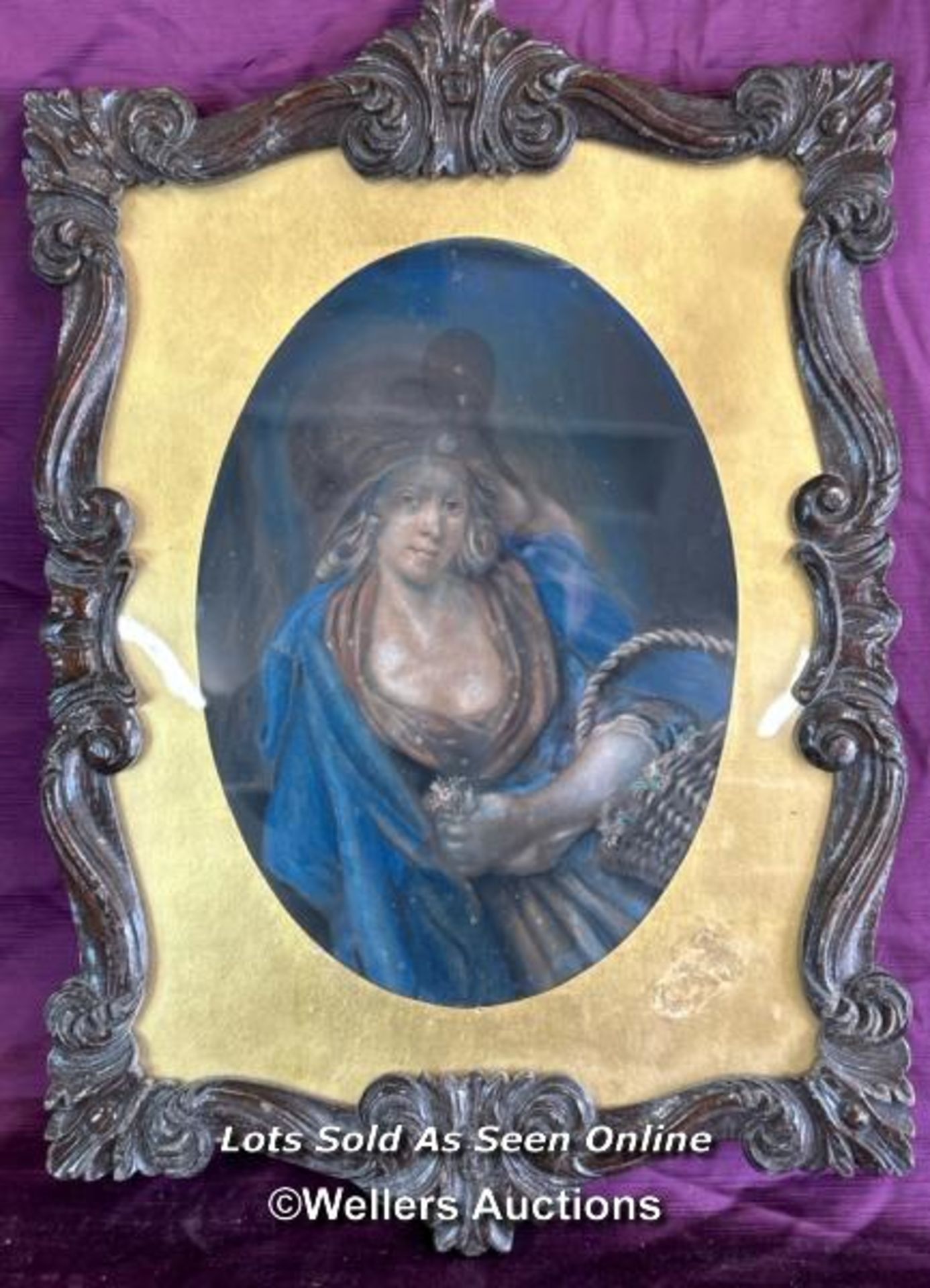 PASTEL ON PAPER PORTRAIT OF A LADY WITH A BASKET AND FLOWERS, IN A DECORATIVE CARVED WOODEN FRAME.