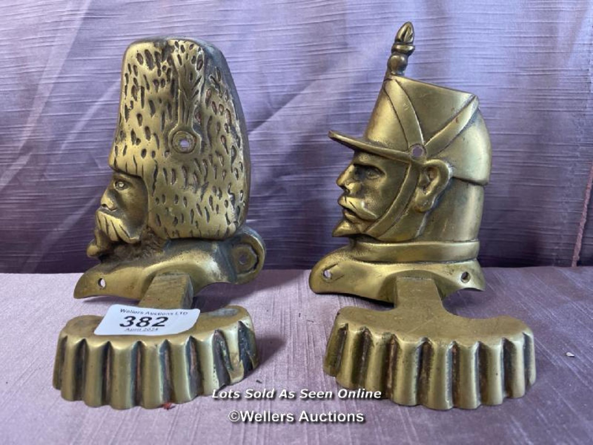 TWO CONTINENTAL BRASS MILITARY BOOK ENDS IN THE FORM OF A FRENCH GRENADIER AND A FRENCH ARTILLARY