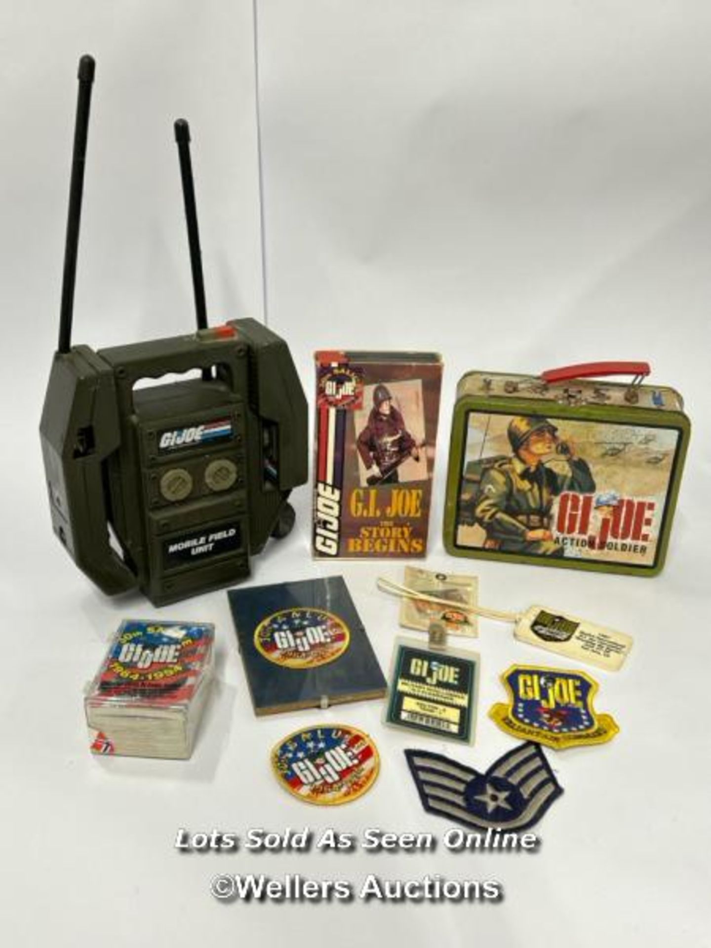 Assorted GI Joe items including mobile field unit phone, tin lunchbox, patches and collectors