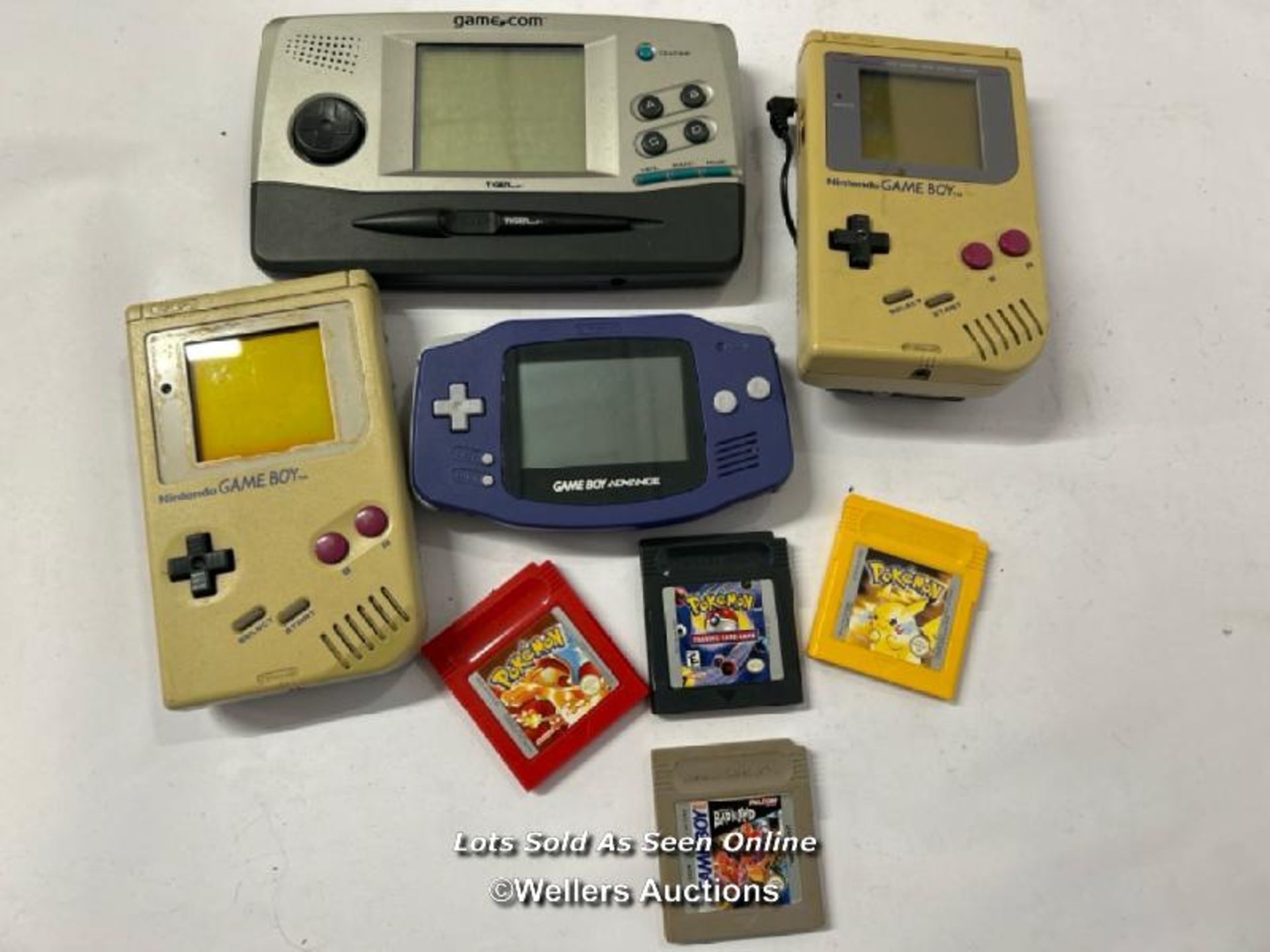 Three vintage hand held Game Boy consoles, all as found with three Pokémon games and Bad 'n' Rad