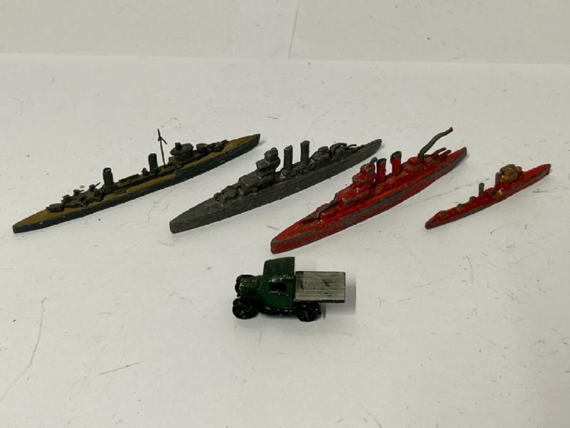 Four small metal warship models and a small metal car / AN21