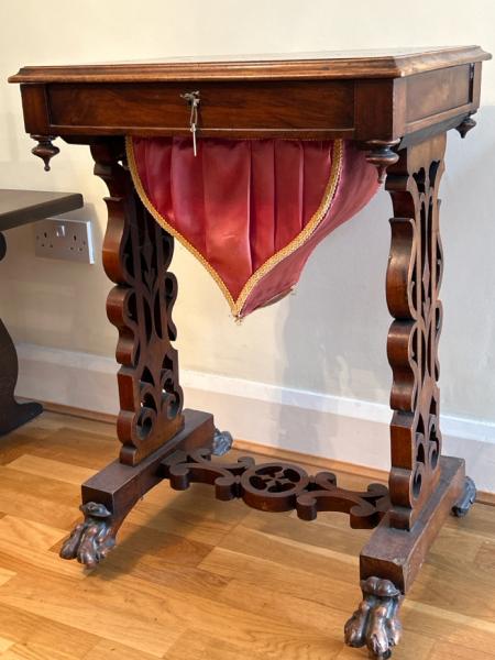 Antique walnut sewing table with sectional interior, clawed feet on casters and working lock with