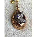 A Faberge style egg pendant with hatching diamond encrusted chick, measuring 20mm x 12mm, the loop