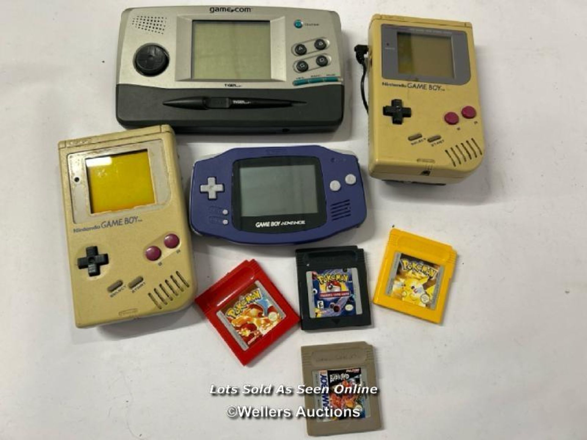 Three vintage hand held Game Boy consoles, all as found with three Pokamon games and Bad 'n' Rad
