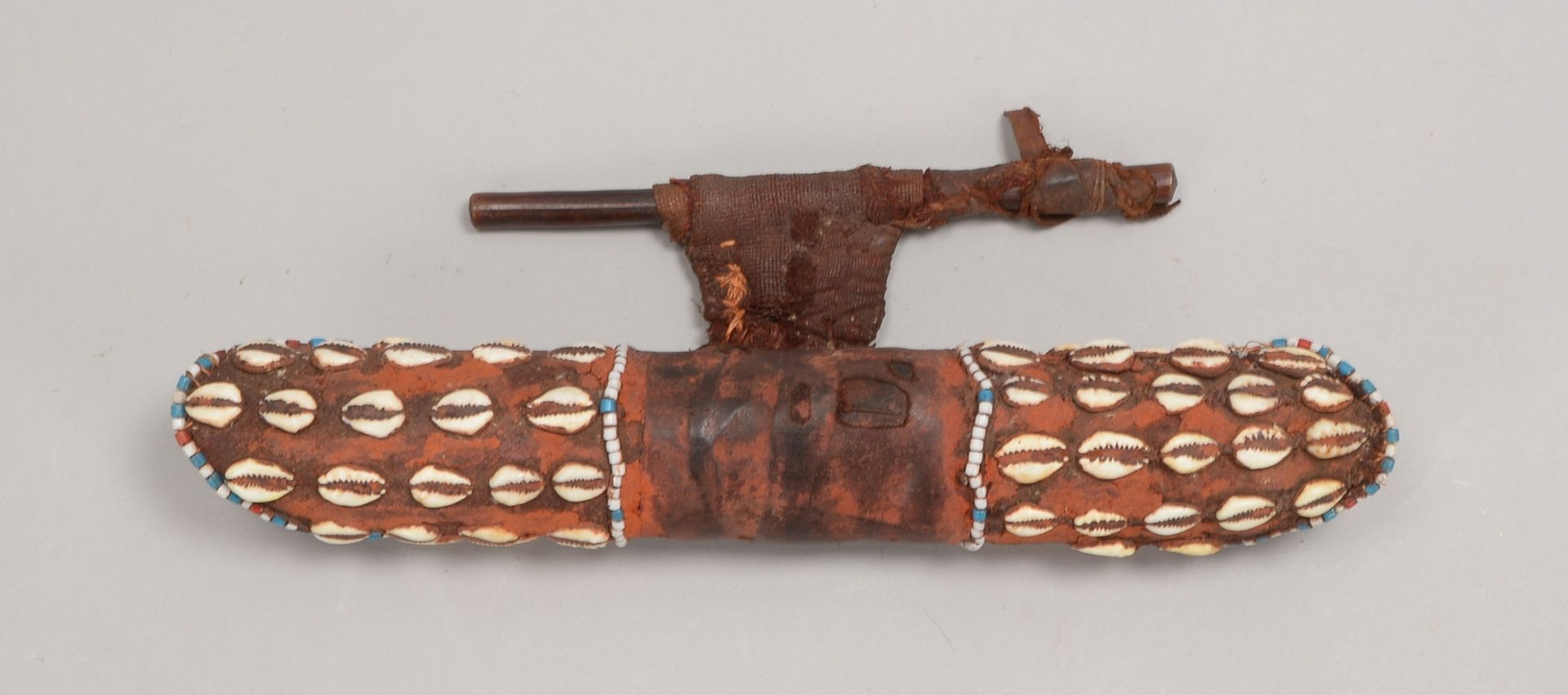 Kult-/Zeremonienobjekt, wohl Holz, mit Leder bezogen, verziert mit Muscheln und Perlen
