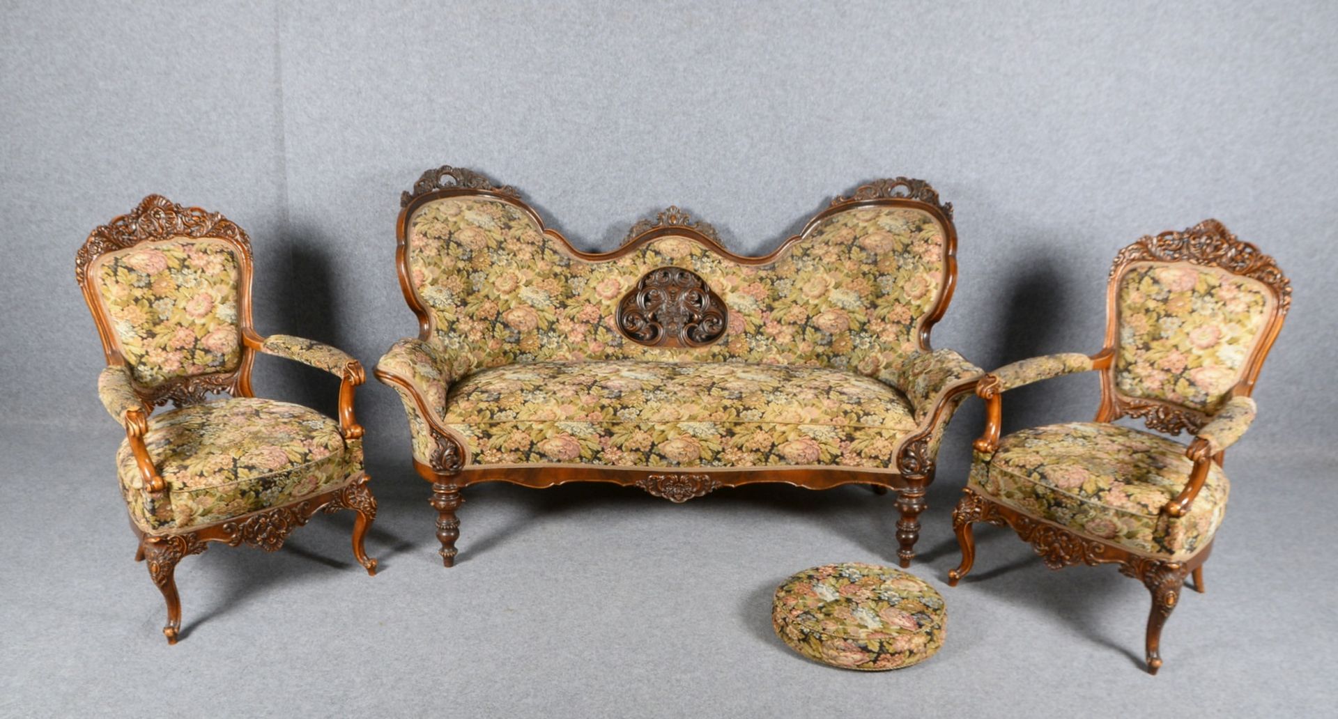 Sofa und 2x Sessel, reiches Schnitzwerk, mit floral gemustertem Polsterstoff - mit Fußkissen