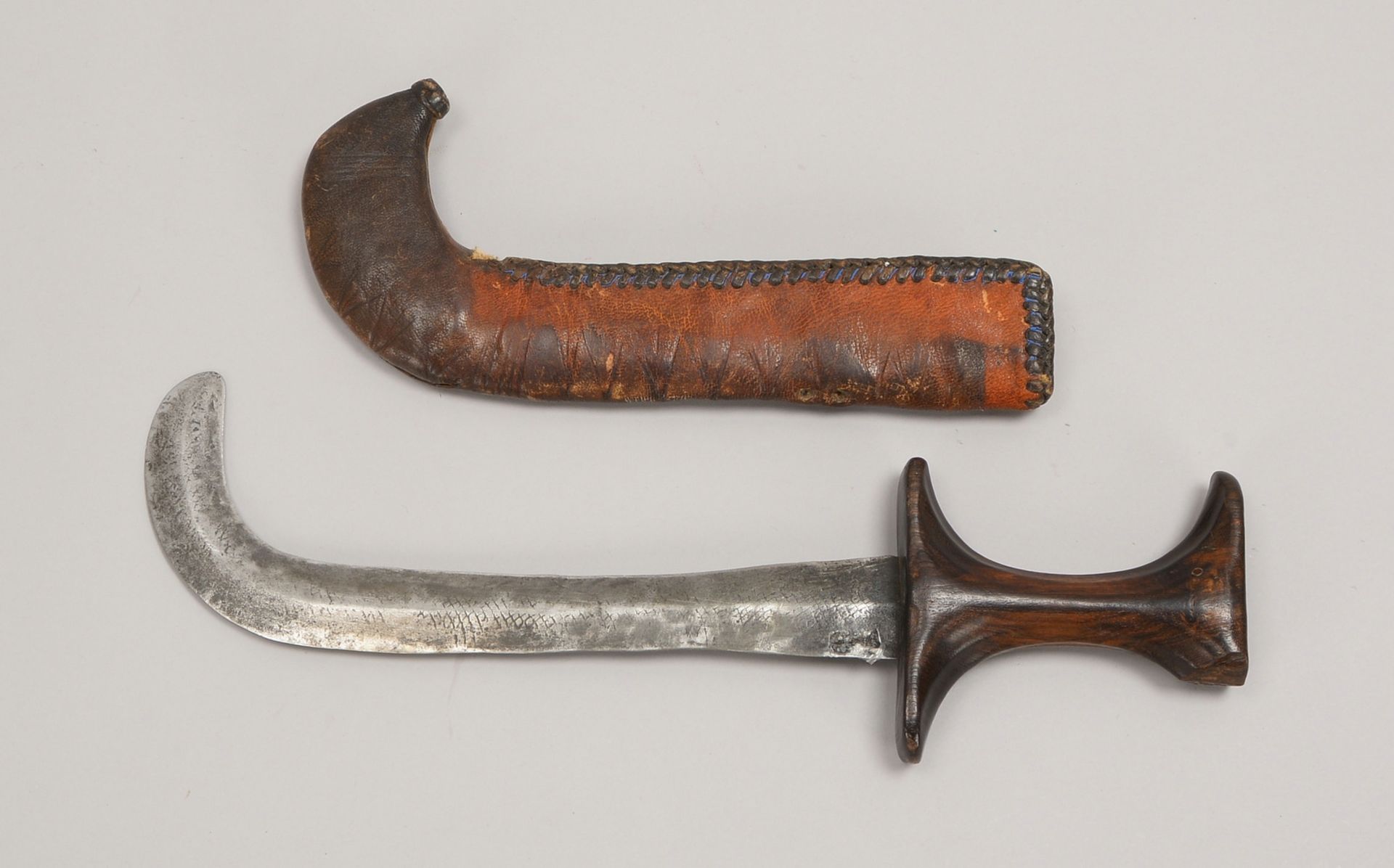 Tuareg-Krummdolch, schmiedeeiserne Klinge, Holzgriff, in Lederscheide; Länge 35 cm