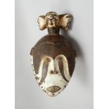 Tanzmaske (Igbo/Nigeria), Holz, janusköpfige Helmmaske, z.T. weiß gef.; Höhe 42 cm