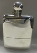 An unusual silver hip flask with matching cup.
