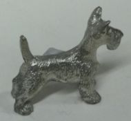 A silver plated figure of a dog. Marked, 'OMM'.