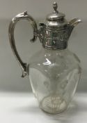 A silver mounted engraved glass claret jug.
