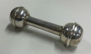 A silver christening baby's rattle in the form of a dumbbell.