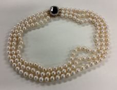A fine quality triple row pearl necklace with large