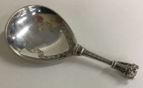 An unsual Continental silver caddy spoon engraved with scrolls.