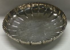 A circular silver strawberry dish of typical form.