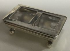 A modern silver and glass stamp box.