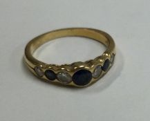 An 18 carat gold sapphire and diamond seven stone half hoop ring.