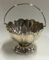 A small silver swing handled basket of shaped form.