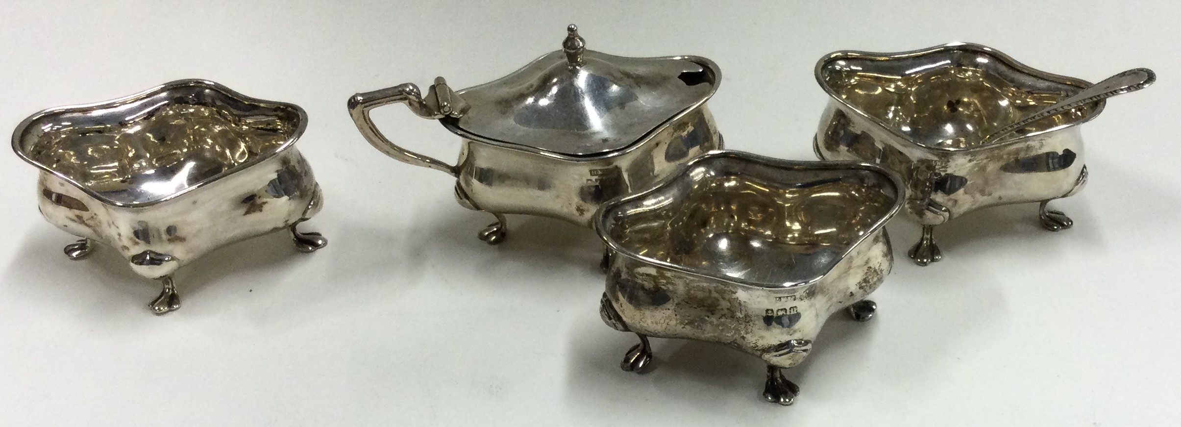 A good silver four piece cruet on scroll feet. Birmingham.