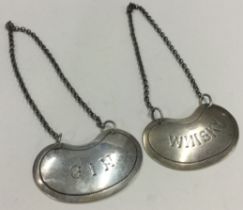 A pair of kidney shaped silver wine labels for 'Gin' and 'Whisky'.