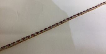 An attractive ruby and diamond line bracelet in 9 carat setting.