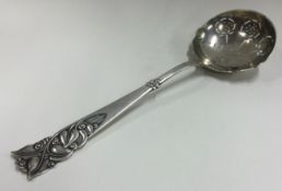 A large silver ladle with pierced and chased handle.