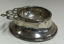 A silver tea strainer on stand. Birmingham. By Mappin & Webb.