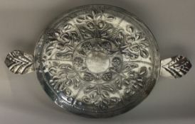 An exquisite Charles II silver dish attractively decorated with flowers and leaves.