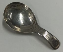 A George III silver caddy spoon with bright cut decoration.