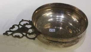 A heavy silver bleeding bowl with pierced handle.