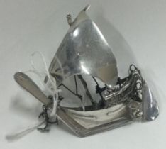 A silver toy model of a galleon.