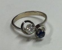 A good diamond and sapphire two stone crossover ring in 14 carat white gold mount.
