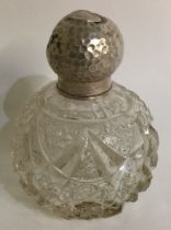A silver and glass scent bottle of hammered design.
