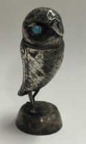 A silver figure of an owl with stone eyes.