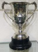 A silver plated cup on plinth.